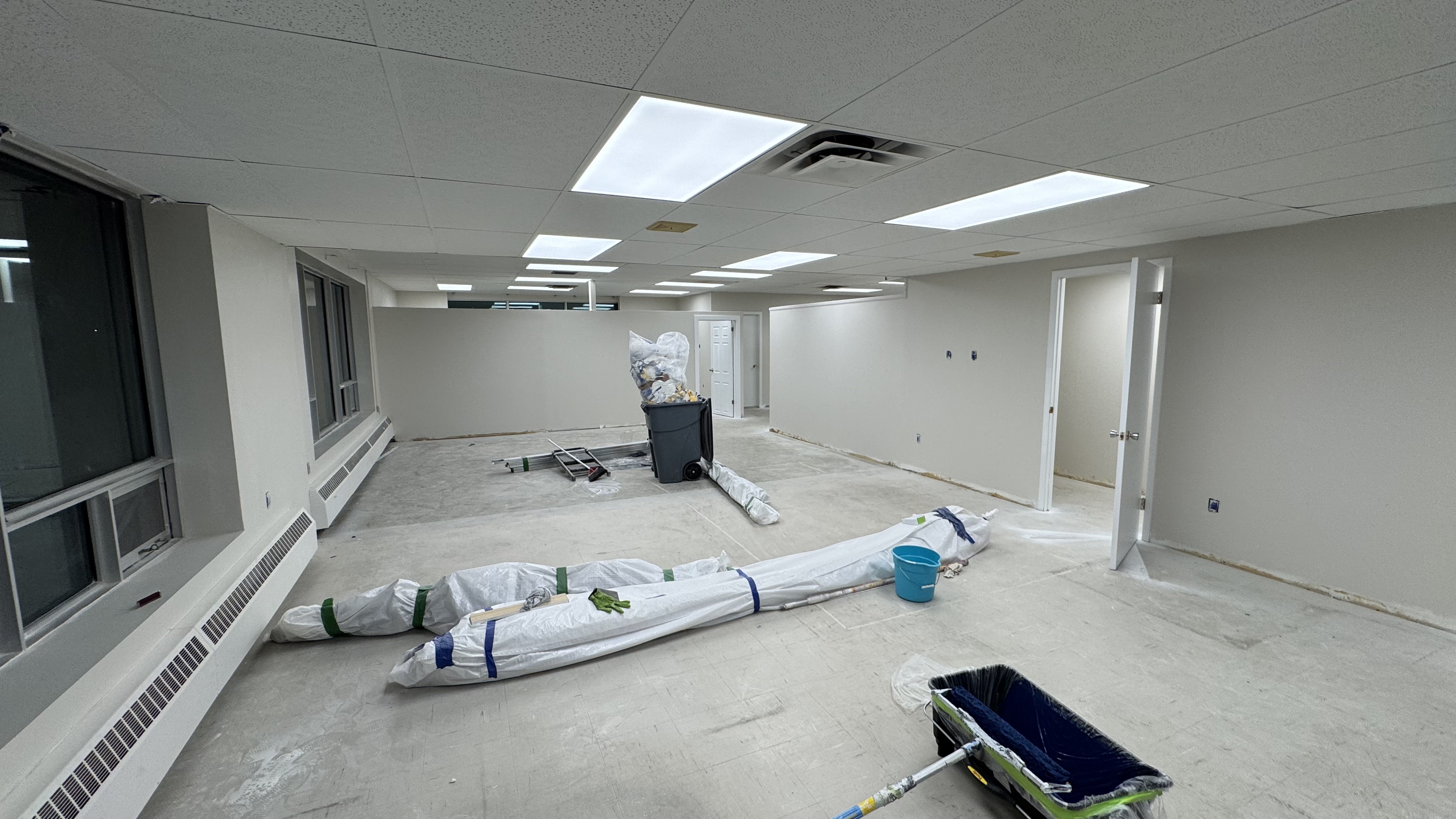 Commercial fit-out: baseboard heaters masked, walls repaired and rolled, room by room — YZ Painting & Finishing, Greater Vancouver