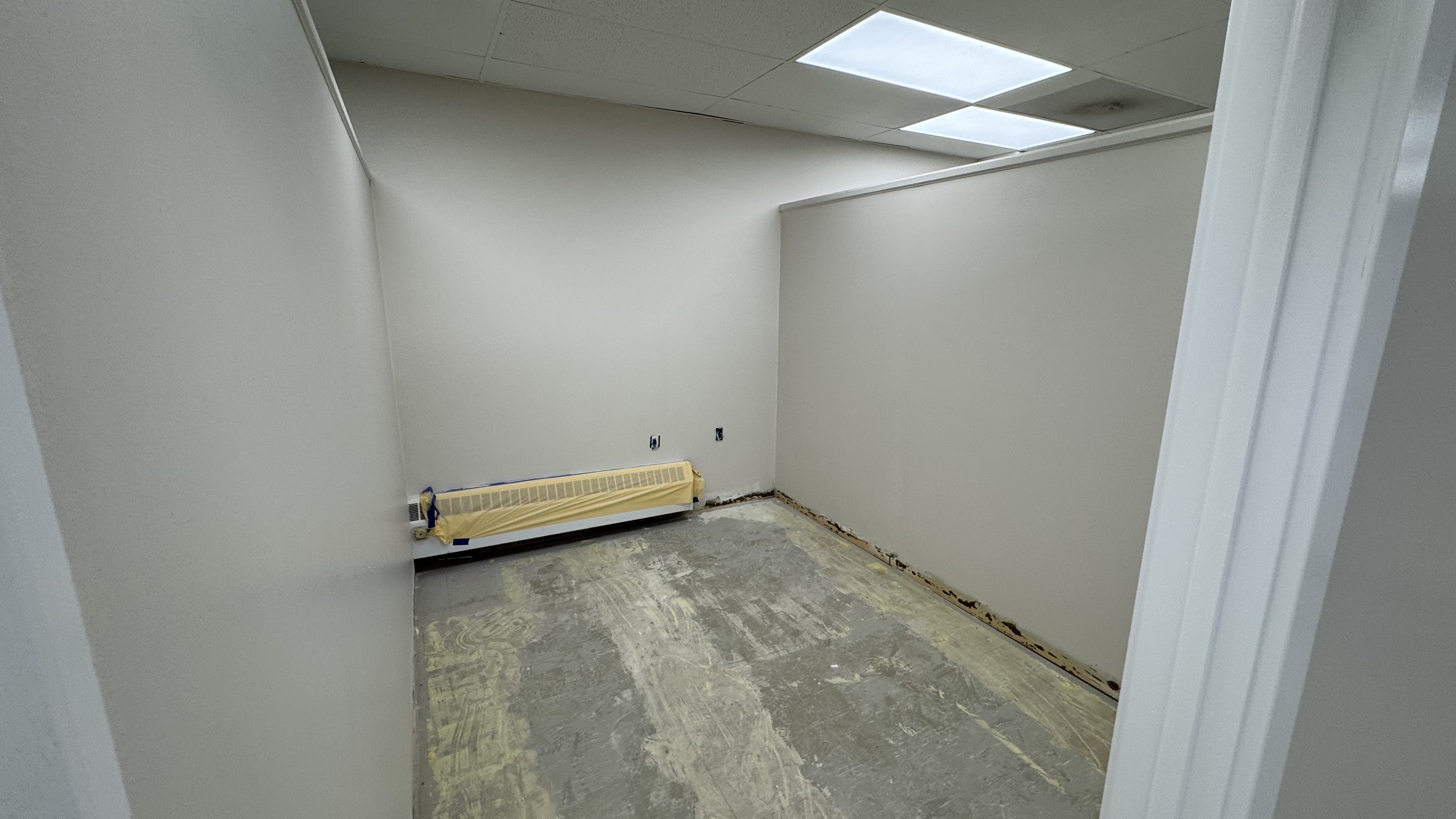 Commercial fit-out: baseboard heaters masked, walls repaired and rolled, room by room — YZ Painting & Finishing, Greater Vancouver