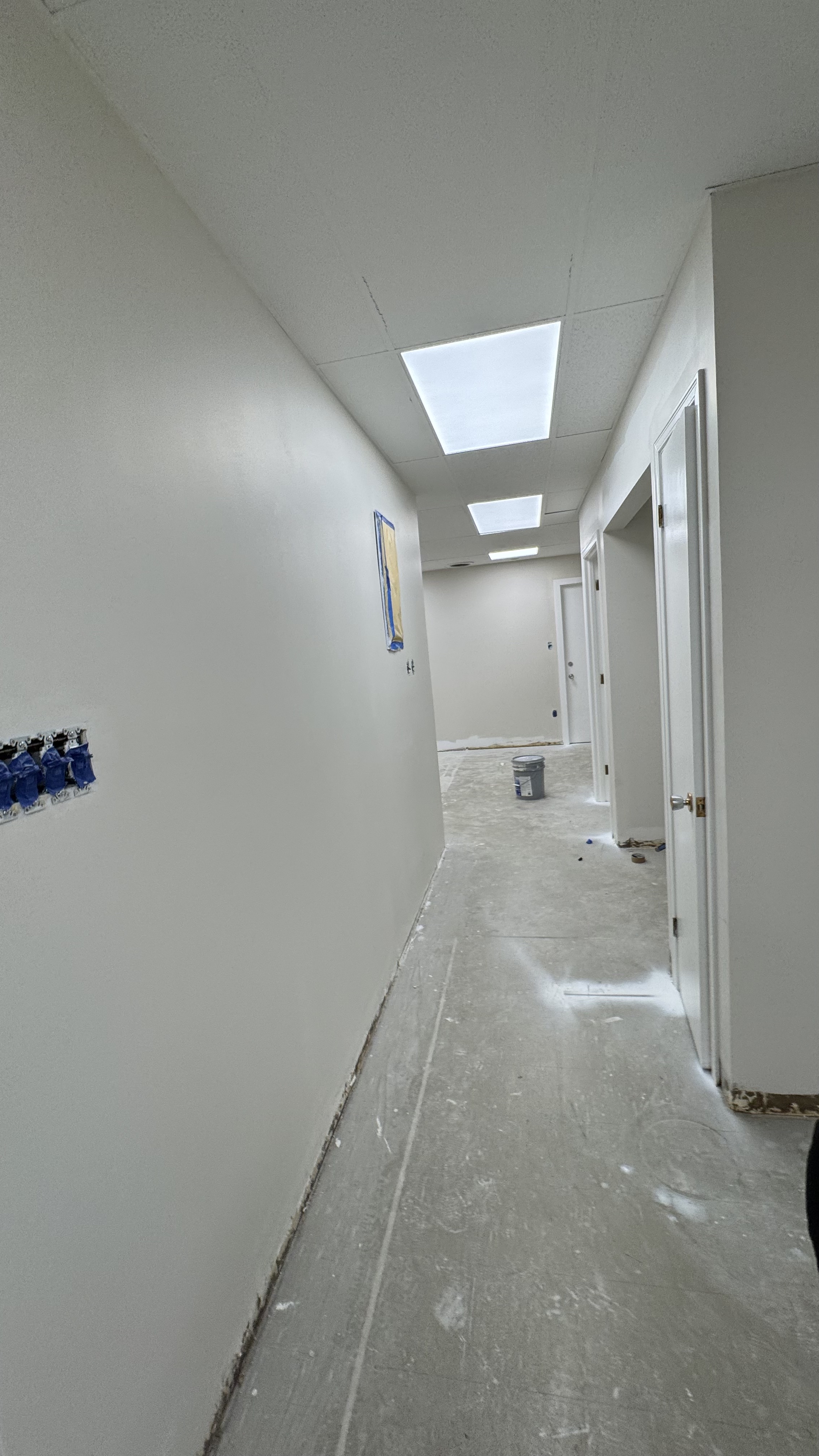 Commercial fit-out: baseboard heaters masked, walls repaired and rolled, room by room — YZ Painting & Finishing, Greater Vancouver