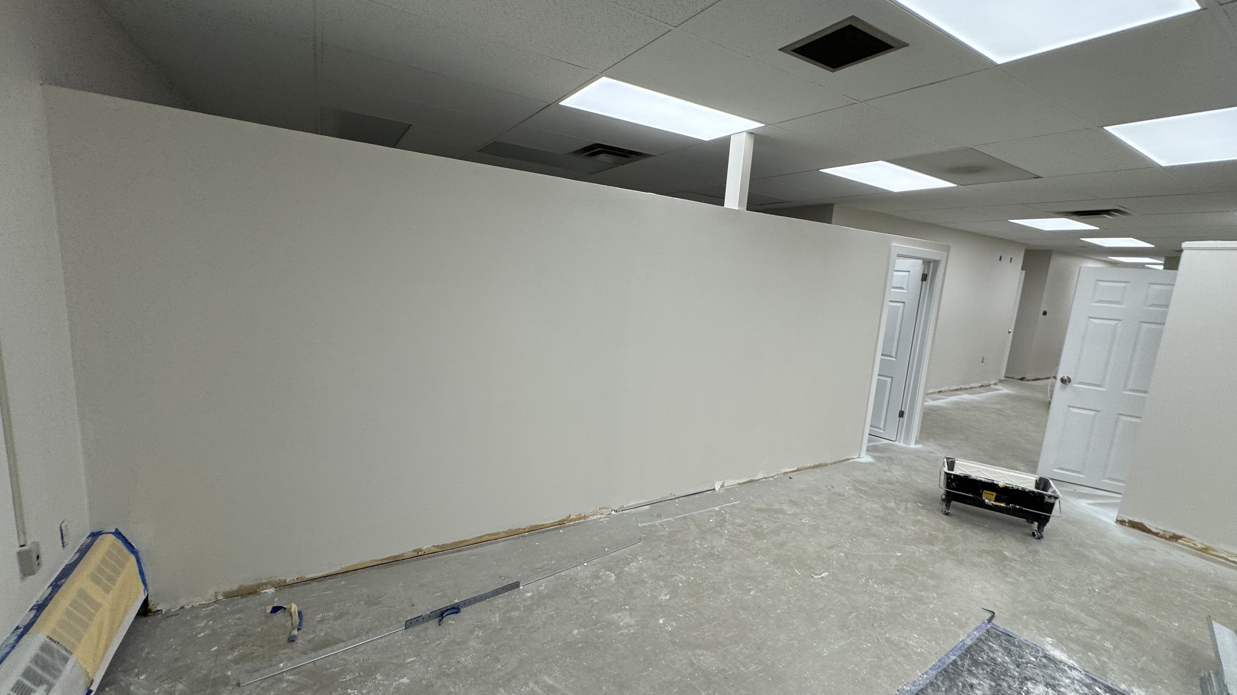 Commercial fit-out: baseboard heaters masked, walls repaired and rolled, room by room — YZ Painting & Finishing, Greater Vancouver