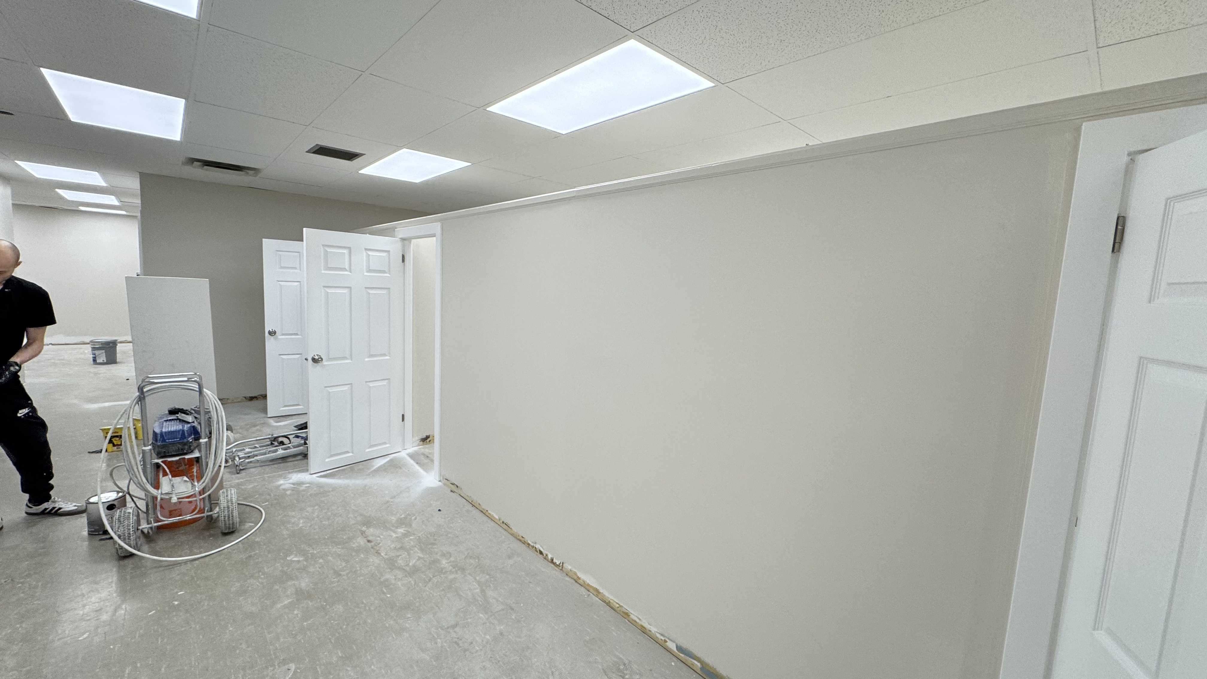 Commercial fit-out: baseboard heaters masked, walls repaired and rolled, room by room — YZ Painting & Finishing, Greater Vancouver