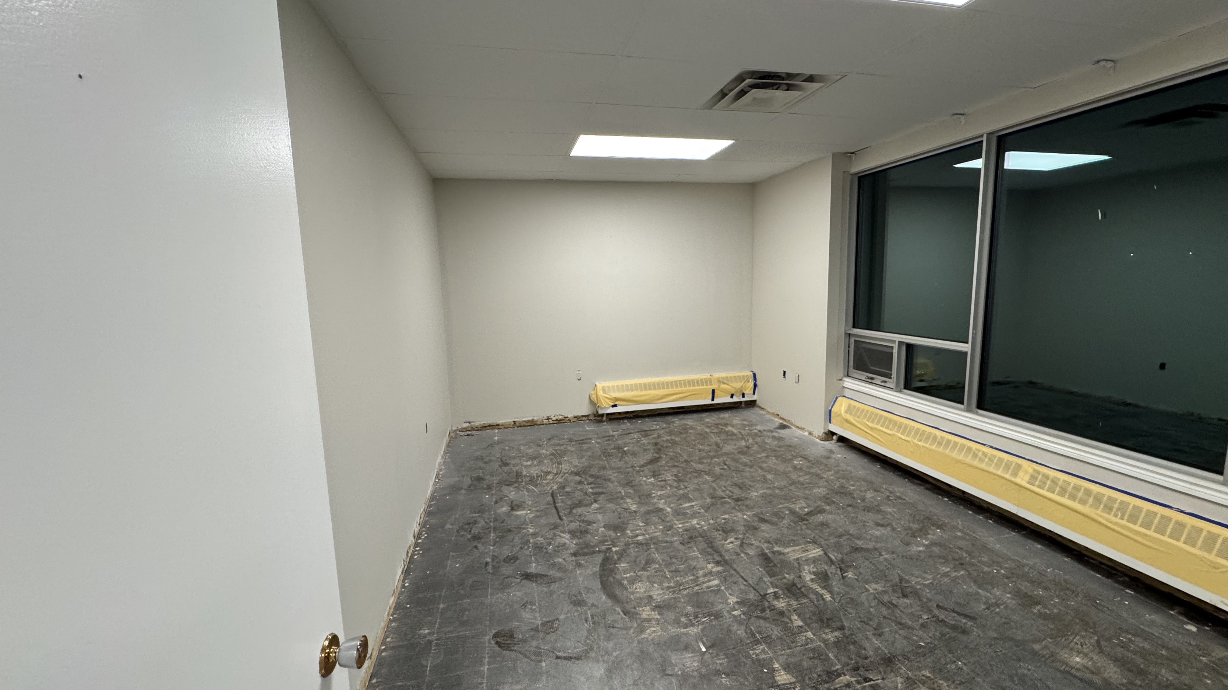 Commercial fit-out: baseboard heaters masked, walls repaired and rolled, room by room — YZ Painting & Finishing, Greater Vancouver