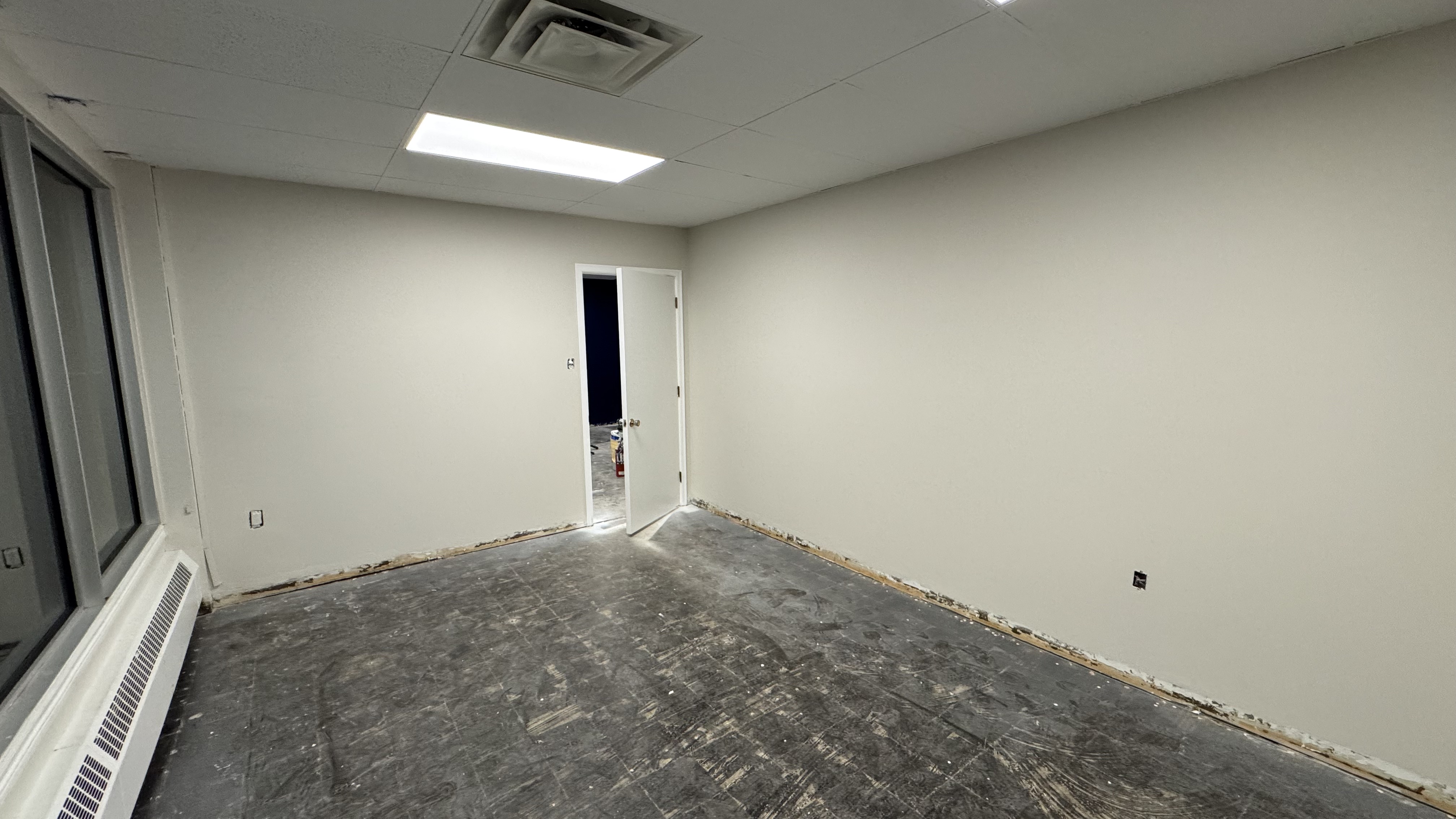 Commercial fit-out: baseboard heaters masked, walls repaired and rolled, room by room — YZ Painting & Finishing, Greater Vancouver