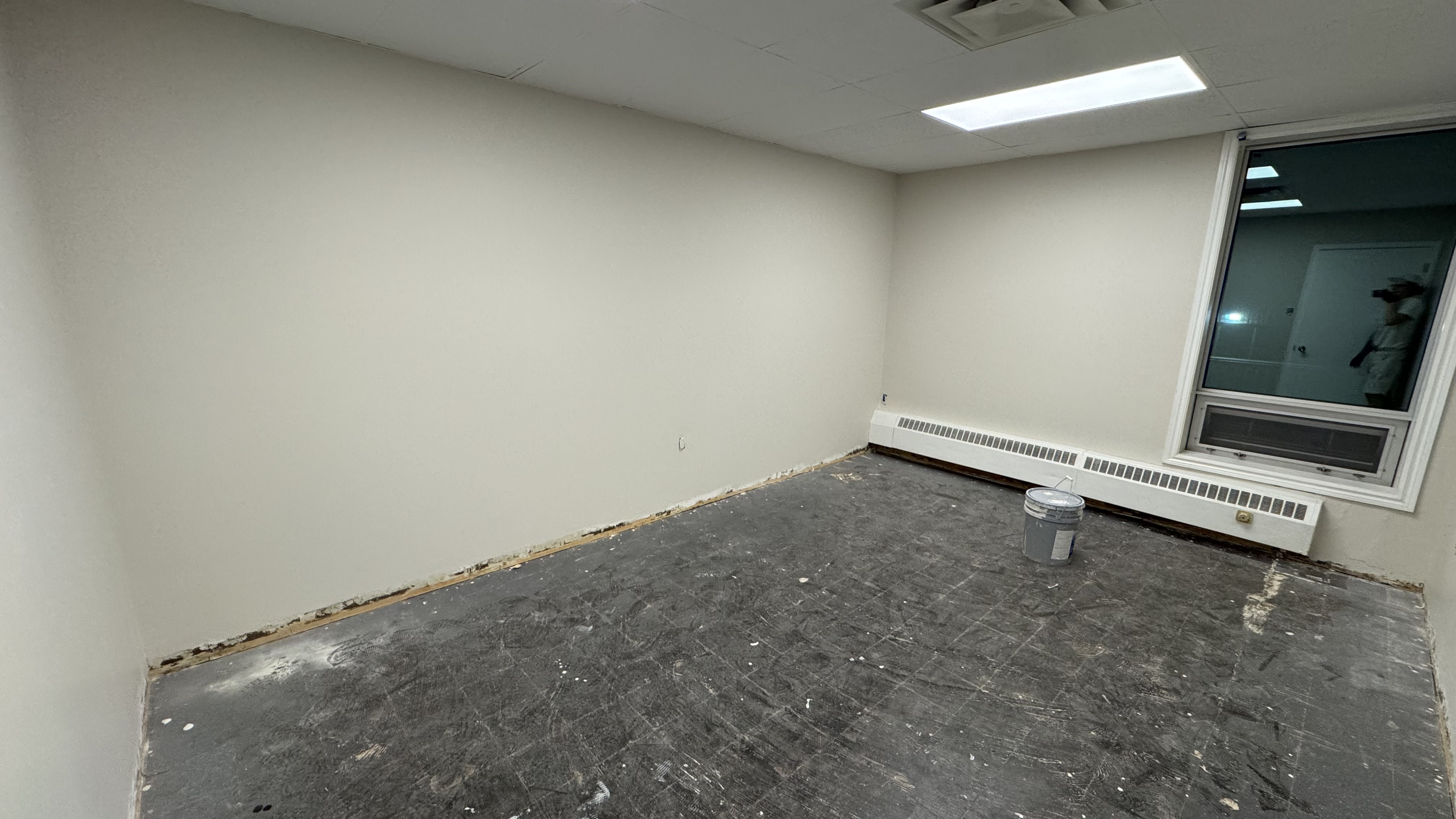 Commercial fit-out: baseboard heaters masked, walls repaired and rolled, room by room — YZ Painting & Finishing, Greater Vancouver