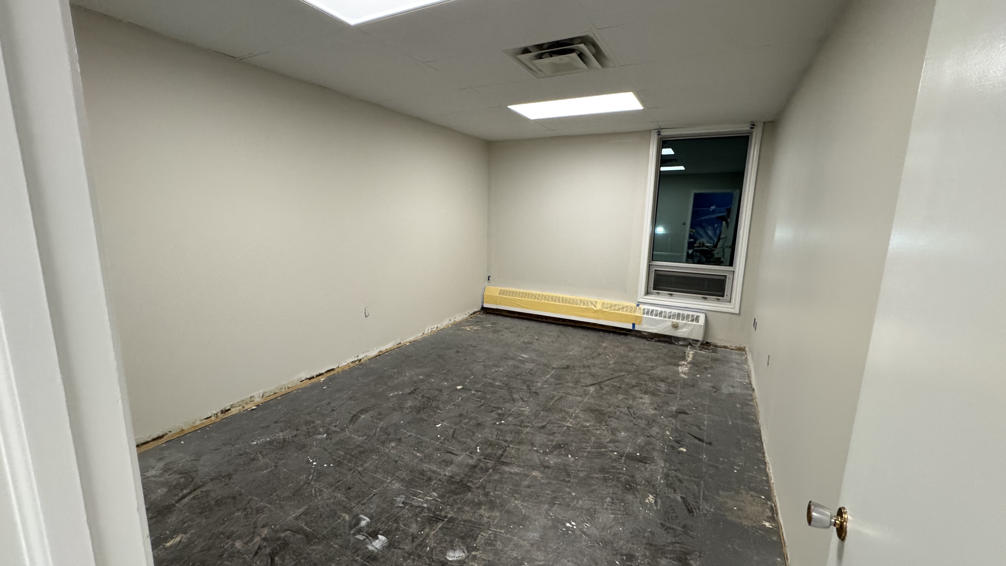 Commercial fit-out: baseboard heaters masked, walls repaired and rolled, room by room — YZ Painting & Finishing, Greater Vancouver
