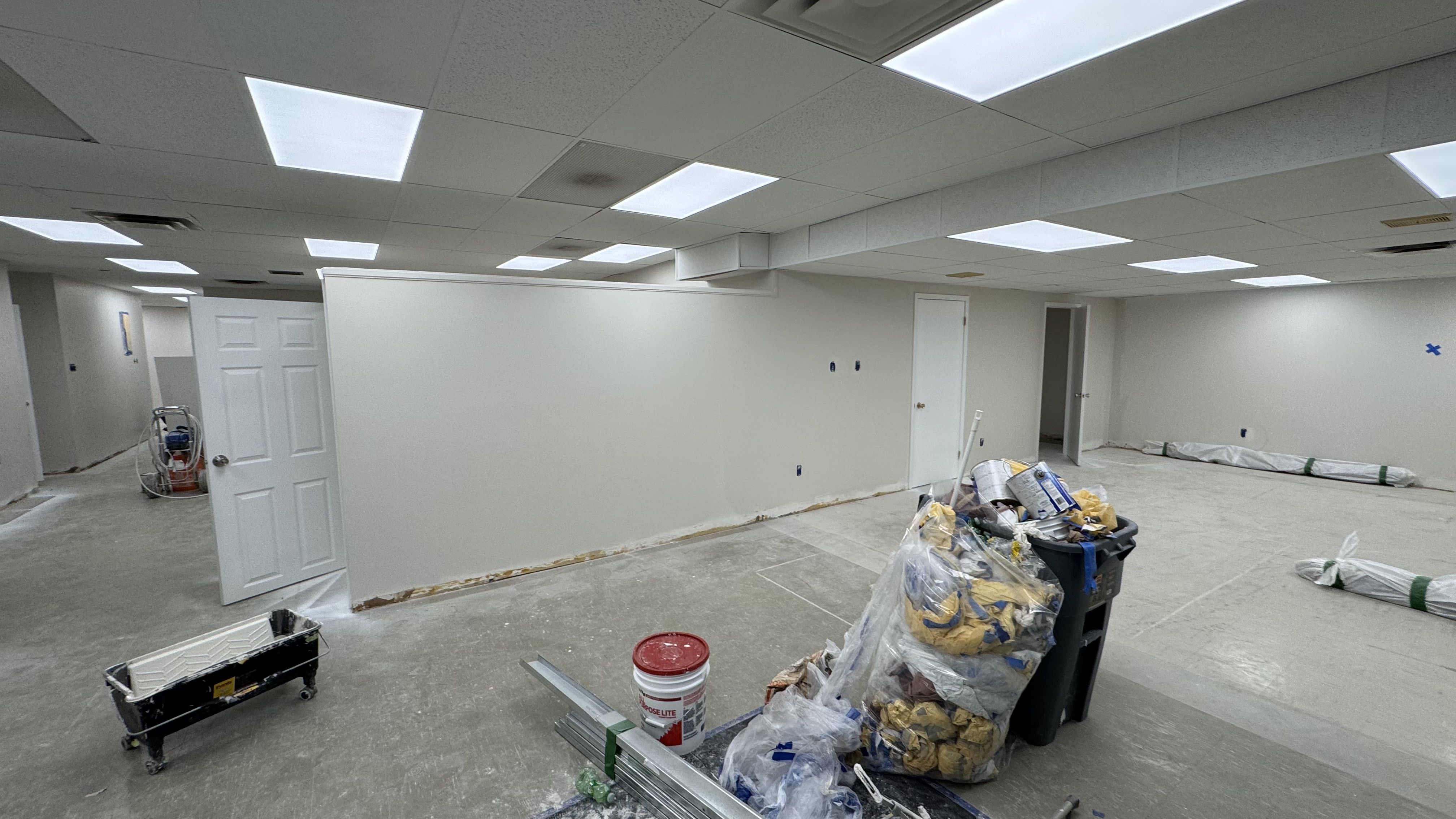 Commercial fit-out: baseboard heaters masked, walls repaired and rolled, room by room — YZ Painting & Finishing, Greater Vancouver