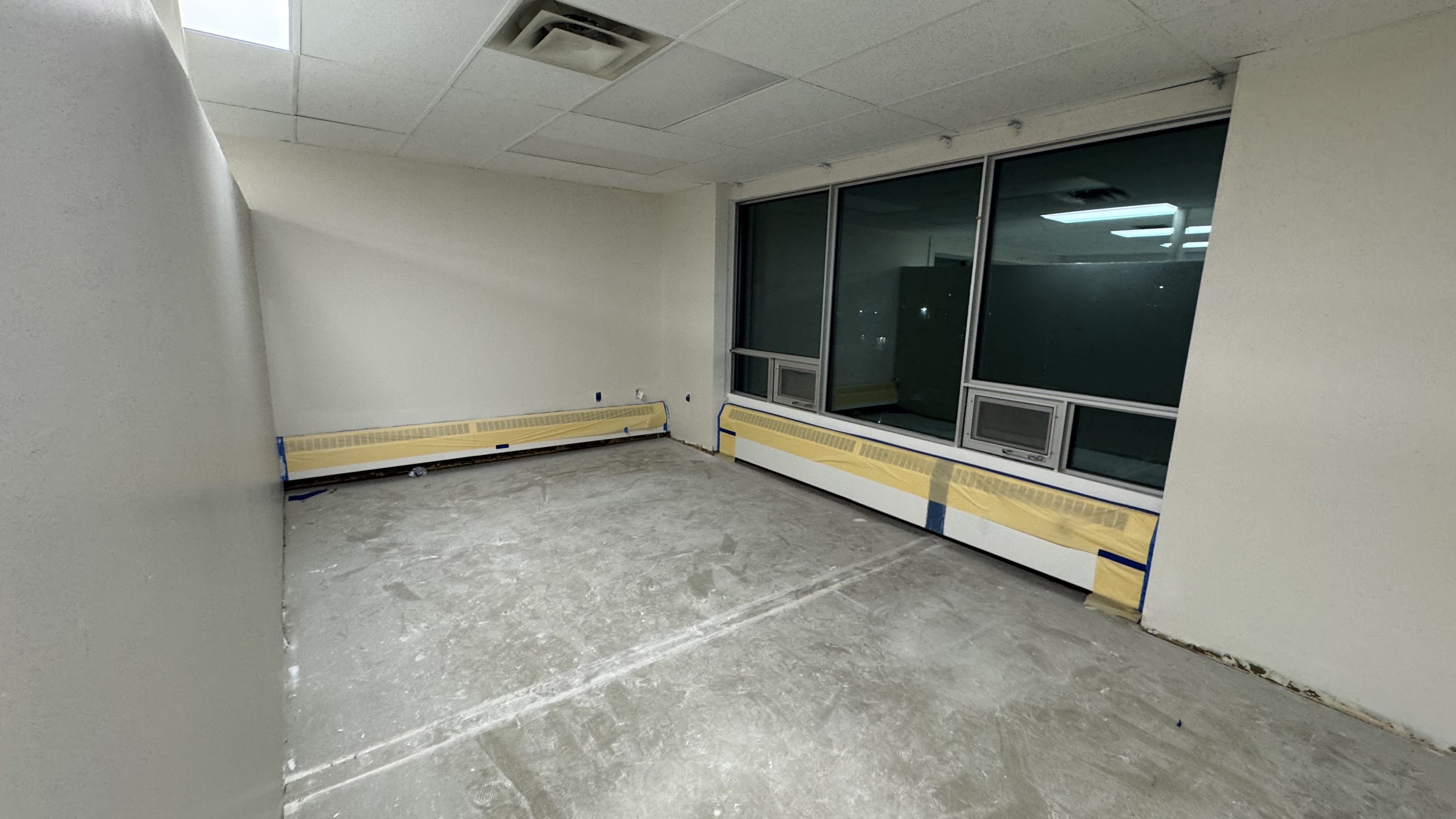 Commercial fit-out: baseboard heaters masked, walls repaired and rolled, room by room — YZ Painting & Finishing, Greater Vancouver