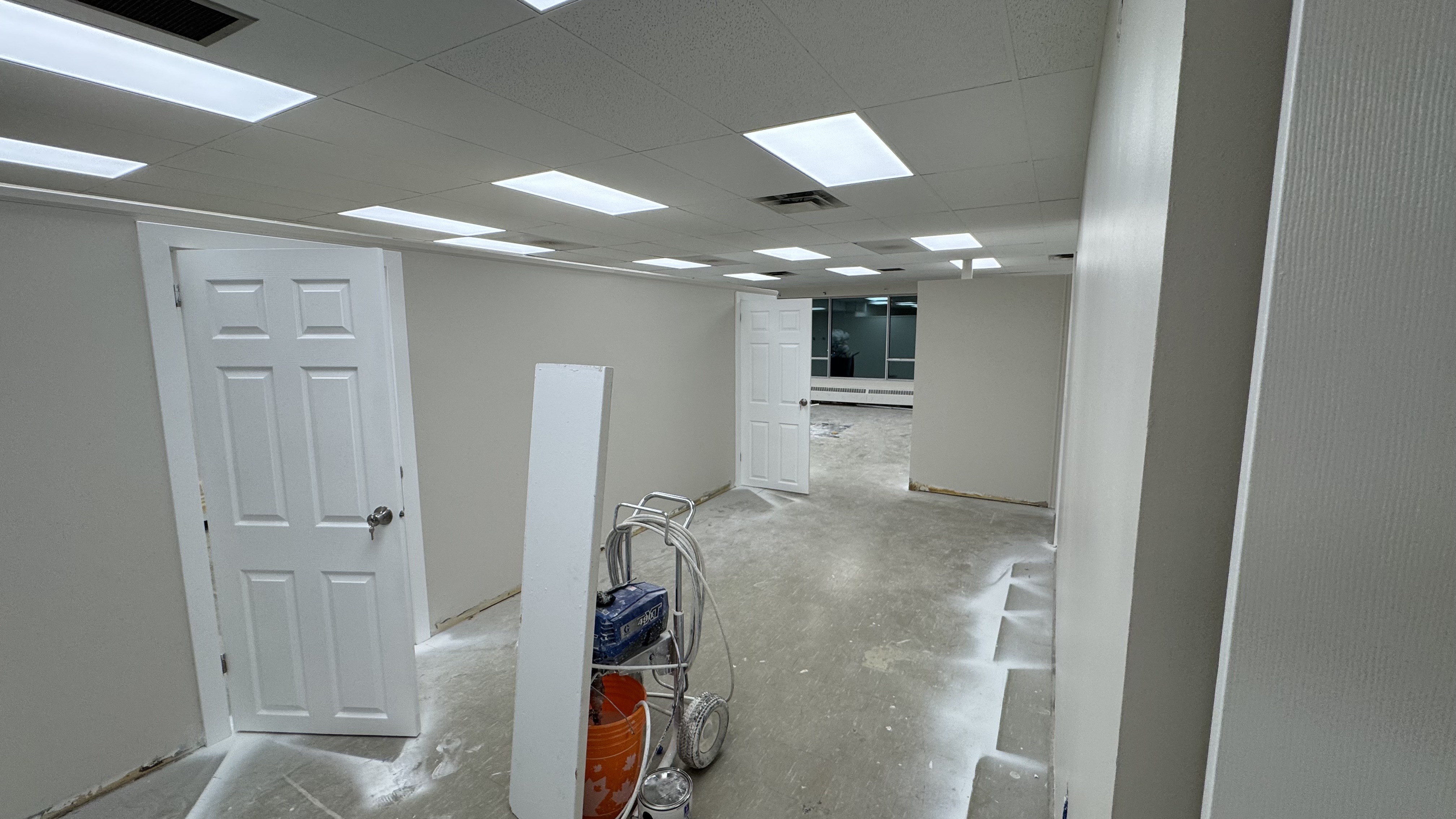 Commercial fit-out: baseboard heaters masked, walls repaired and rolled, room by room — YZ Painting & Finishing, Greater Vancouver